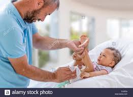 Baby Changing. Loving father changing diaper of his baby daughter.,Little child, girl on changing table in bathroom with rattle toys. Happy dad Stock Photo - Alamy